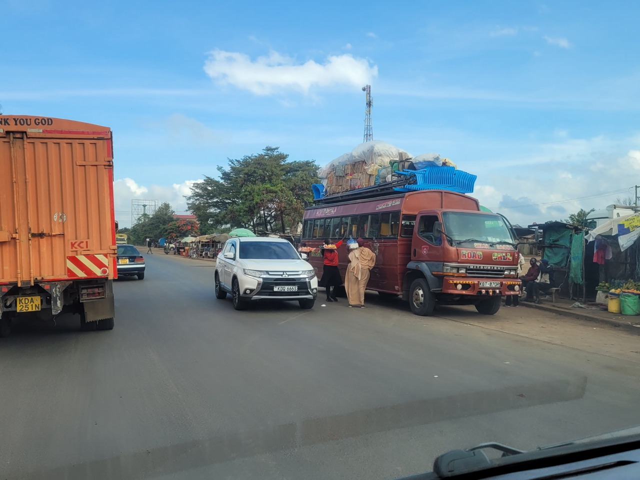 Overloaded truck and bus traffic on a Kenyan highway