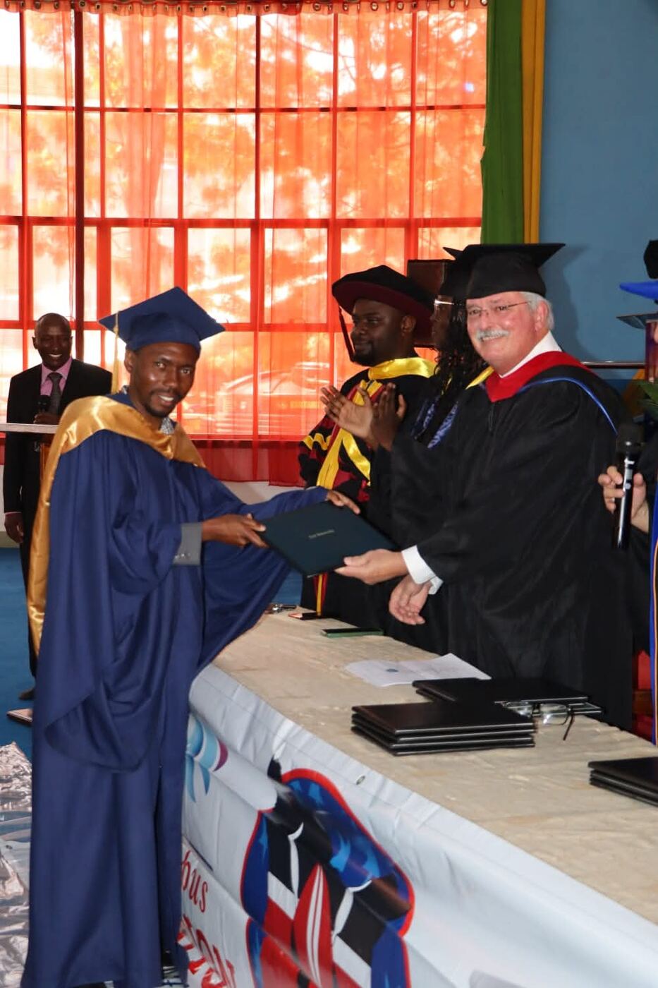 Mike Bourassa presenting a diploma to a graduate