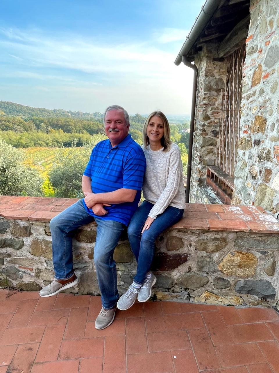 Mike and Tonya Bourassa overlooking a vineyard in Tuscany